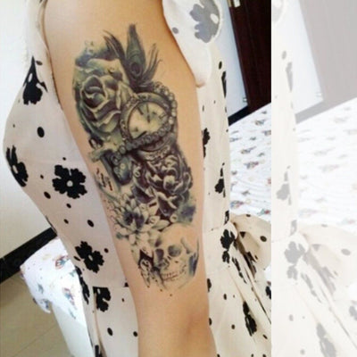 Tatouage temporaire hyperréaliste Over the Seas de ArtWear Tattoo Tête de mort sur le bras d'un homme et jambe d'une femme