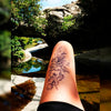 Tatouage temporaire hyperréaliste Black Peony de ArtWear Tattoo Fleurs sur le bras d'un homme et jambe d'une femme