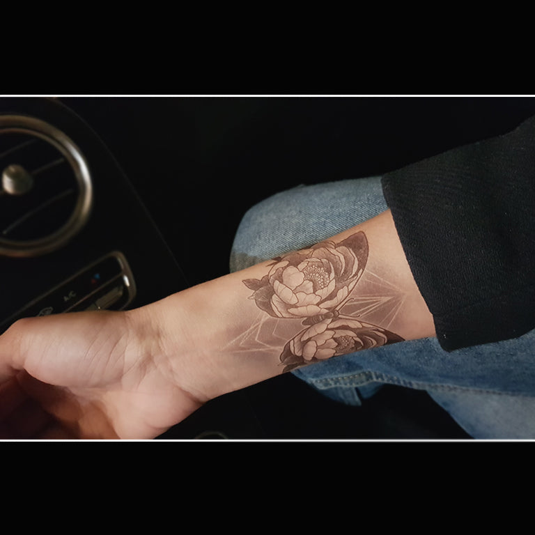 Tatouage temporaire hyperréaliste Peony Butterfly - by Gent de ArtWear Tattoo Collaborations sur le bras d'un homme et jambe d'une femme