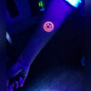 Tatouage temporaire hyperréaliste Glow in the Dark Peace & Flowers - Pack de ArtWear Tattoo Fluorescents & Phosphorescents sur le bras d'un homme et jambe d'une femme