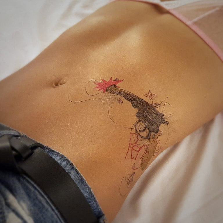 Tatouage temporaire hyperréaliste Bang Bang de ArtWear Tattoo Cartoon sur le bras d'un homme et jambe d'une femme