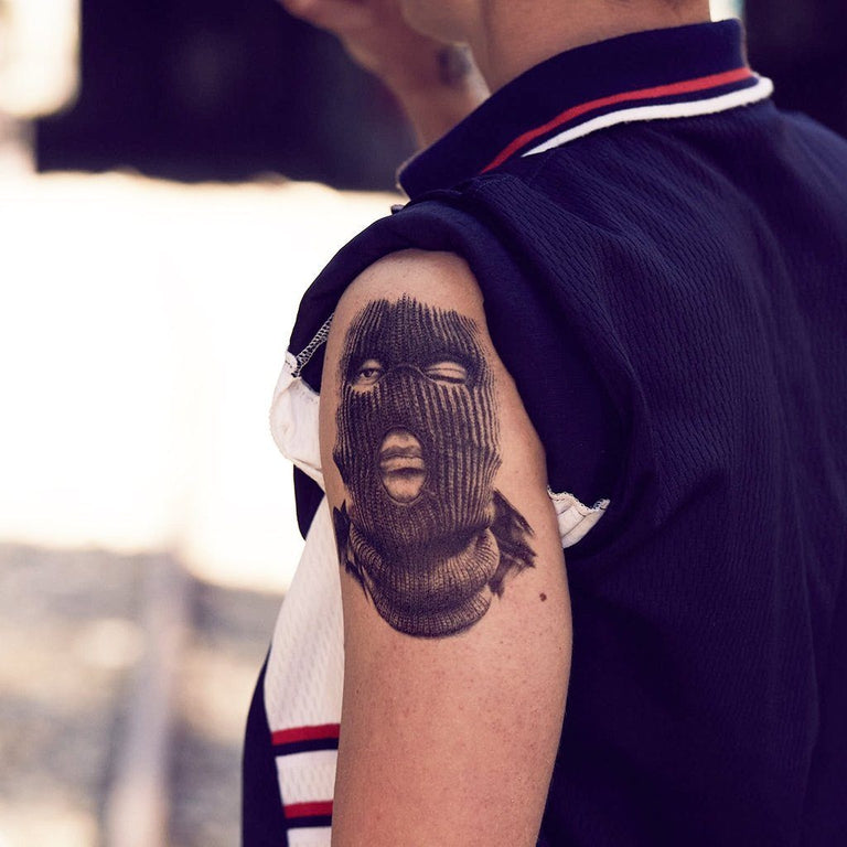 Tatouage temporaire hyperréaliste Hood Gangster de ArtWear Tattoo Cartoon sur le bras d'un homme et jambe d'une femme