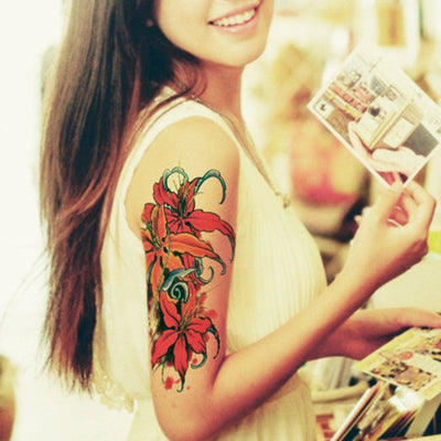 Tatouage temporaire hyperréaliste Red Flowers de ArtWear Tattoo Fleurs sur le bras d'un homme et jambe d'une femme