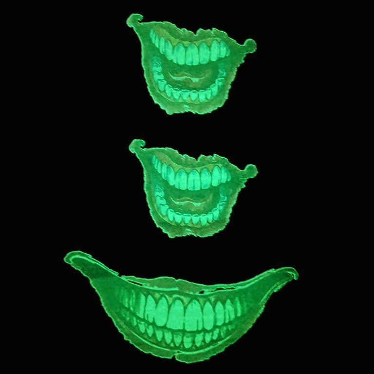 Tatouage temporaire hyperréaliste Glow in the Dark Joker Smile - Pack de ArtWear Tattoo Fluorescents & Phosphorescents sur le bras d'un homme et jambe d'une femme