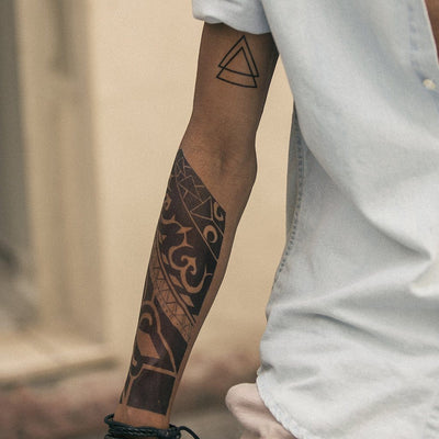 Tatouage temporaire hyperréaliste Black Maori Forearm de ArtWear Tattoo Maori/Polynésien sur le bras d'un homme et jambe d'une femme