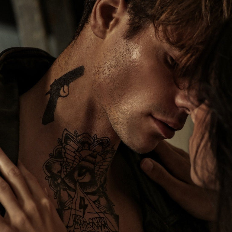 Tatouage temporaire hyperréaliste 2 Lil Guns de ArtWear Tattoo Minimalistes sur le bras d'un homme et jambe d'une femme
