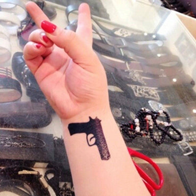 Tatouage temporaire hyperréaliste 2 Lil Guns de ArtWear Tattoo Minimalistes sur le bras d'un homme et jambe d'une femme