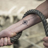 Tatouage temporaire hyperréaliste Small Compass de ArtWear Tattoo Minimalistes sur le bras d'un homme et jambe d'une femme