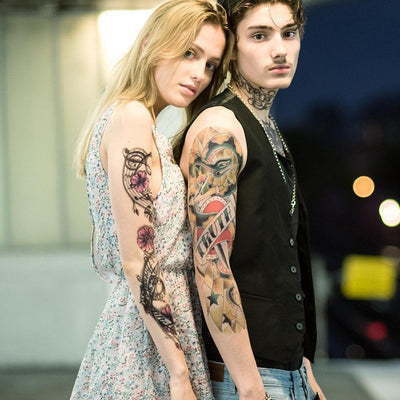 Tatouage temporaire hyperréaliste Music Sheet Sleeve de ArtWear Tattoo Sleeve sur le bras d'un homme et jambe d'une femme