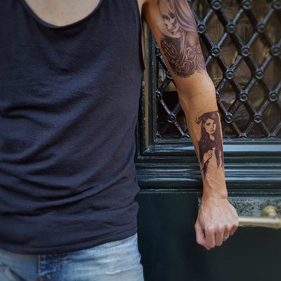 Tatouage temporaire hyperréaliste Prayer for the Dead de ArtWear Tattoo Tête de mort sur le bras d'un homme et jambe d'une femme