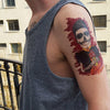 Tatouage temporaire hyperréaliste Rock n' Roll de ArtWear Tattoo Tête de mort sur le bras d'un homme et jambe d'une femme