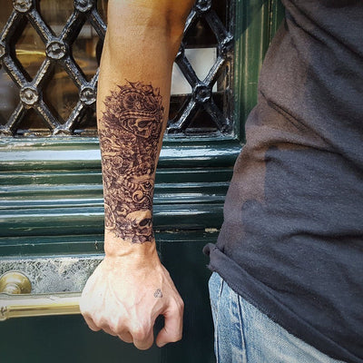 Tatouage temporaire hyperréaliste Skull & Players de ArtWear Tattoo Tête de mort sur le bras d'un homme et jambe d'une femme