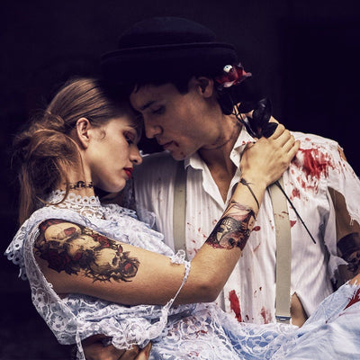 Tatouage temporaire hyperréaliste Skull & Roses 4 de ArtWear Tattoo Tête de mort sur le bras d'un homme et jambe d'une femme
