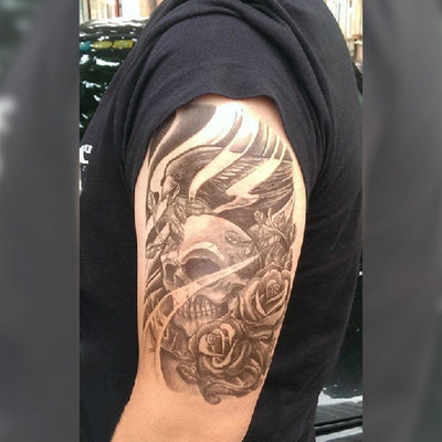 Tatouage temporaire hyperréaliste Skull Roses & Bird de ArtWear Tattoo Tête de mort sur le bras d'un homme et jambe d'une femme