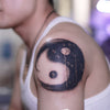 Tatouage temporaire hyperréaliste Yin & Yang de ArtWear Tattoo Traditionnels sur le bras d'un homme et jambe d'une femme